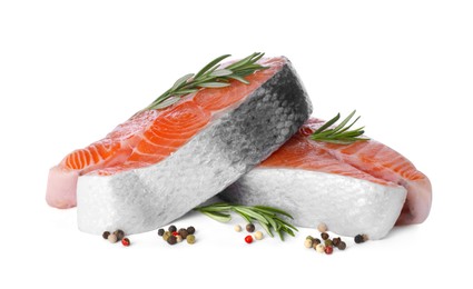 Fresh raw salmon steaks with rosemary and peppercorns on white background