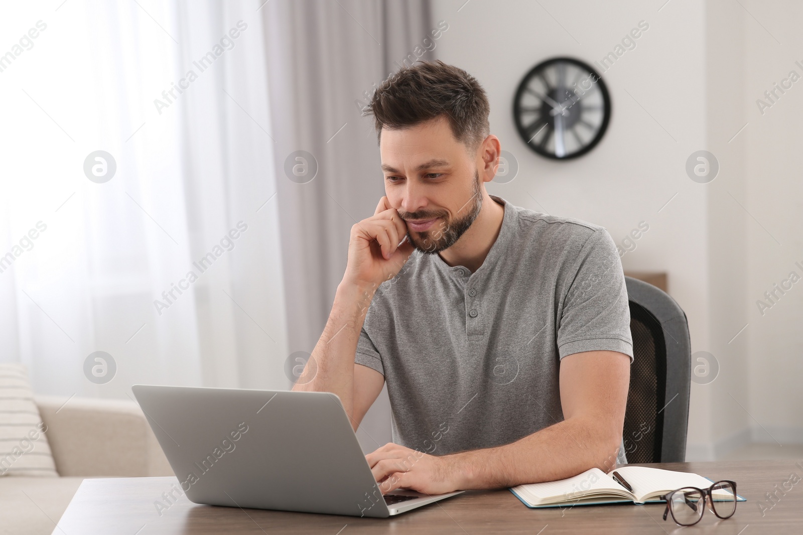 Photo of Man studying on laptop at home. Online translation course