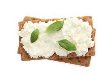 Photo of Crispy crackers with cottage cheese and basil on white background, top view