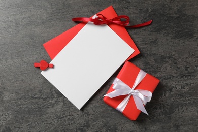 Photo of Blank card, envelope and gift box on grey background, flat lay with space for text. Valentine's Day celebration