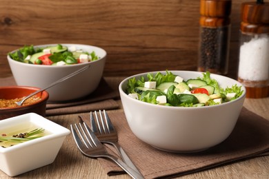 Photo of Tasty fresh salad with cucumber served on wooden table