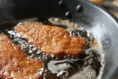 Cooking schnitzels in frying pan, closeup view