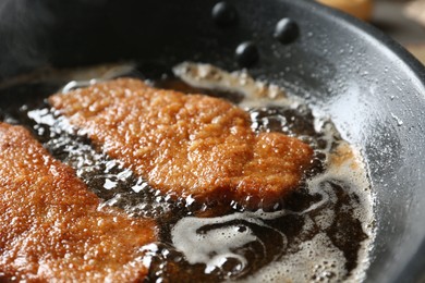 Photo of Cooking schnitzels in frying pan, closeup view