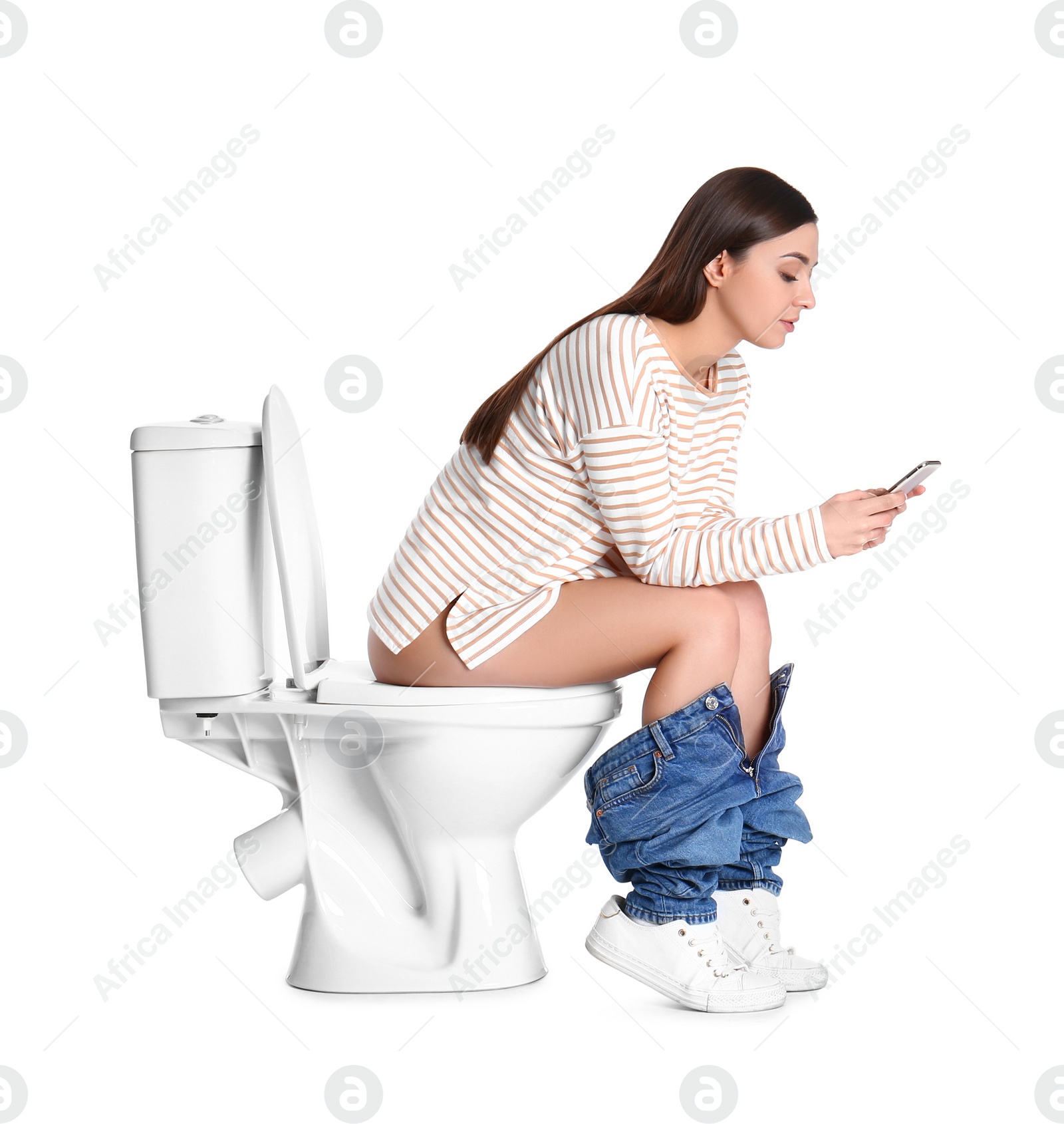 Photo of Woman with smartphone sitting on toilet bowl, white background