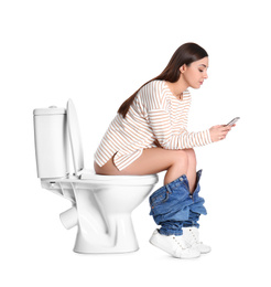 Photo of Woman with smartphone sitting on toilet bowl, white background