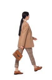 Photo of Young businesswoman with stylish bag walking on white background