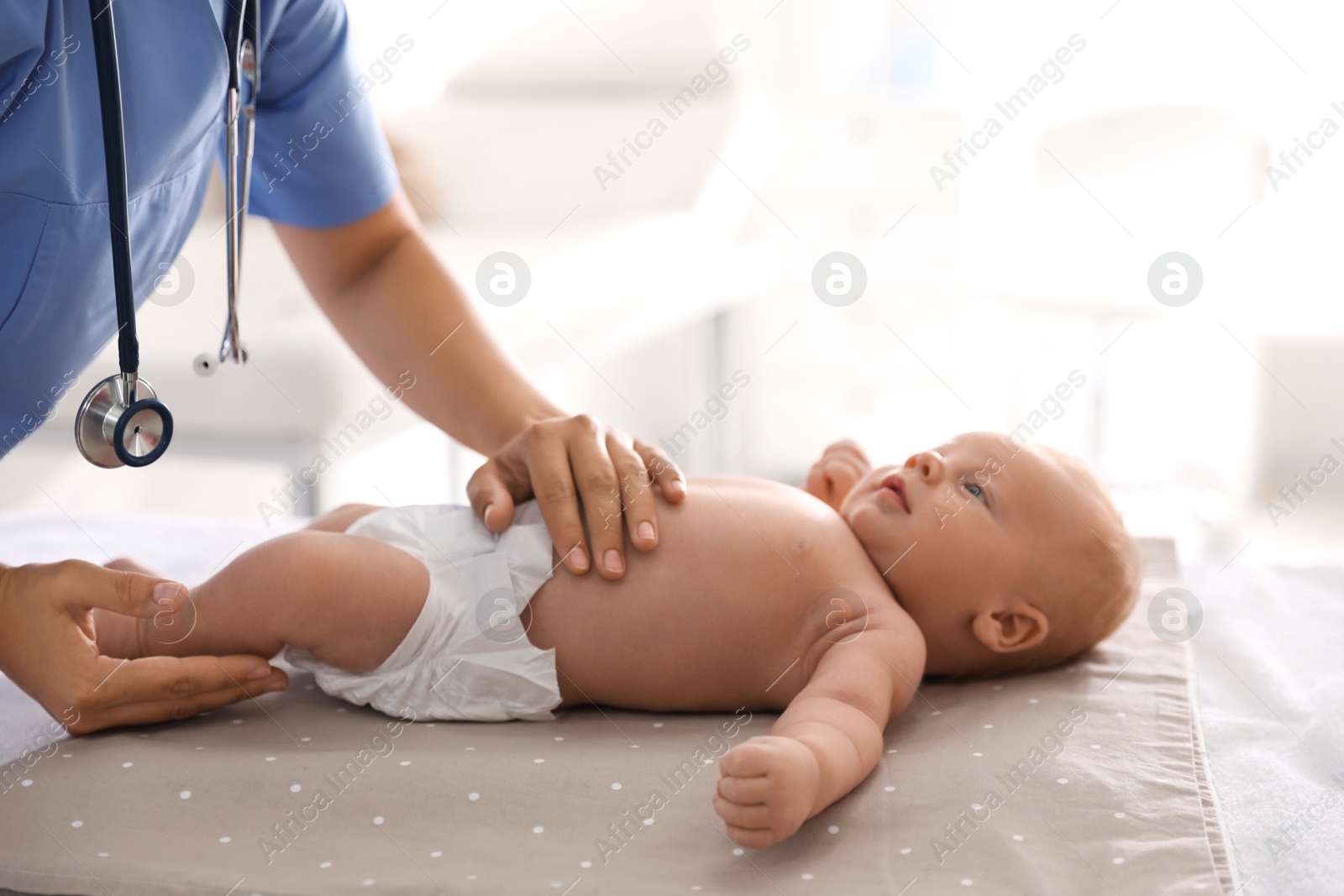 Photo of Doctor examining cute baby in clinic, closeup. Health care