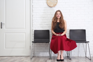 Photo of Young woman waiting for job interview, indoors