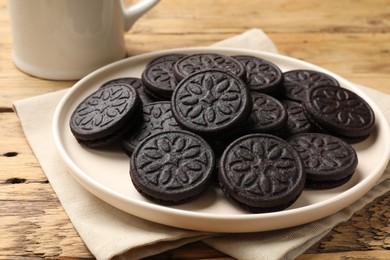 Photo of Plate with tasty sandwich cookies on wooden table, closeup