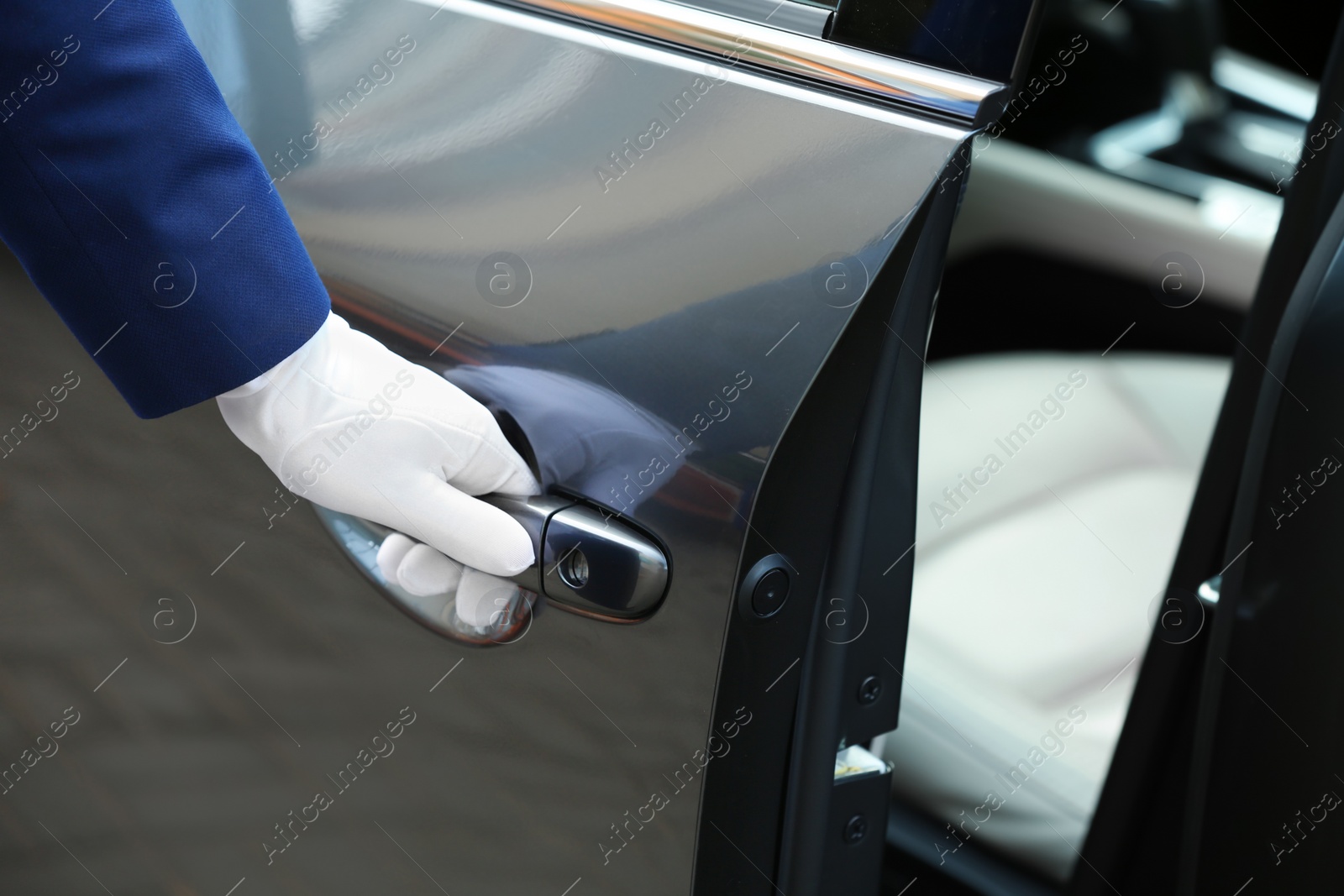 Photo of Closeup view of chauffeur opening car door