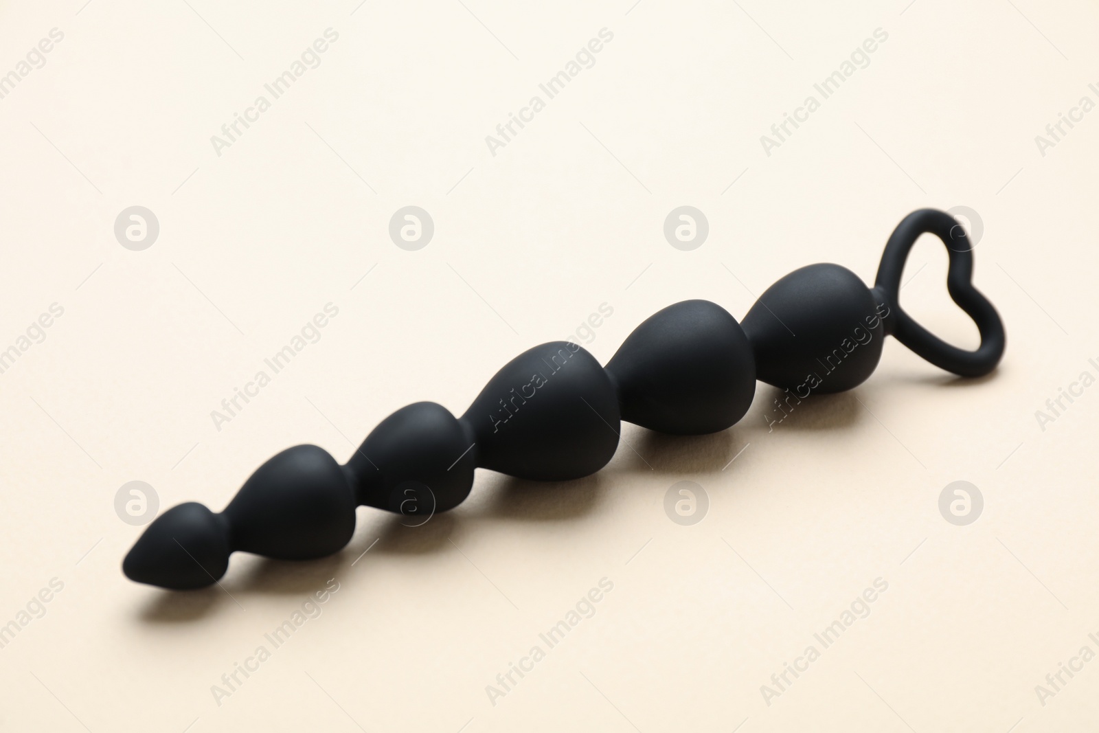 Photo of Anal beads on beige background. Sex toy