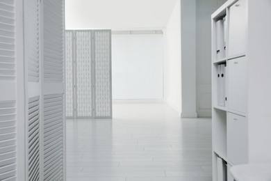 Photo of Empty office corridor with white walls and wooden floor