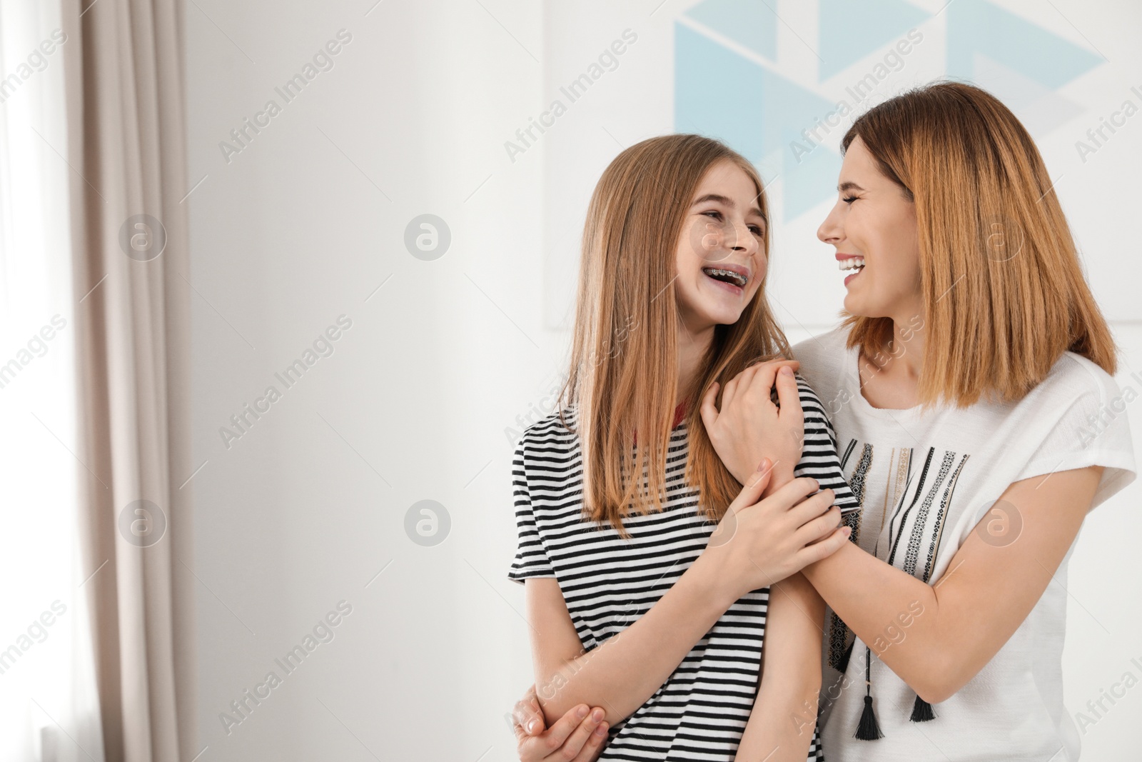 Photo of Happy mother hugging her teenager daughter at home