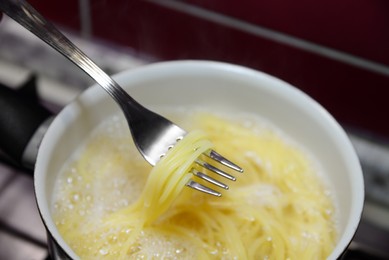 Cooking pasta in saucepan on stove, closeup