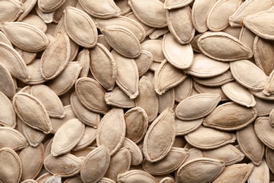 Photo of Raw pumpkin seeds as background, top view