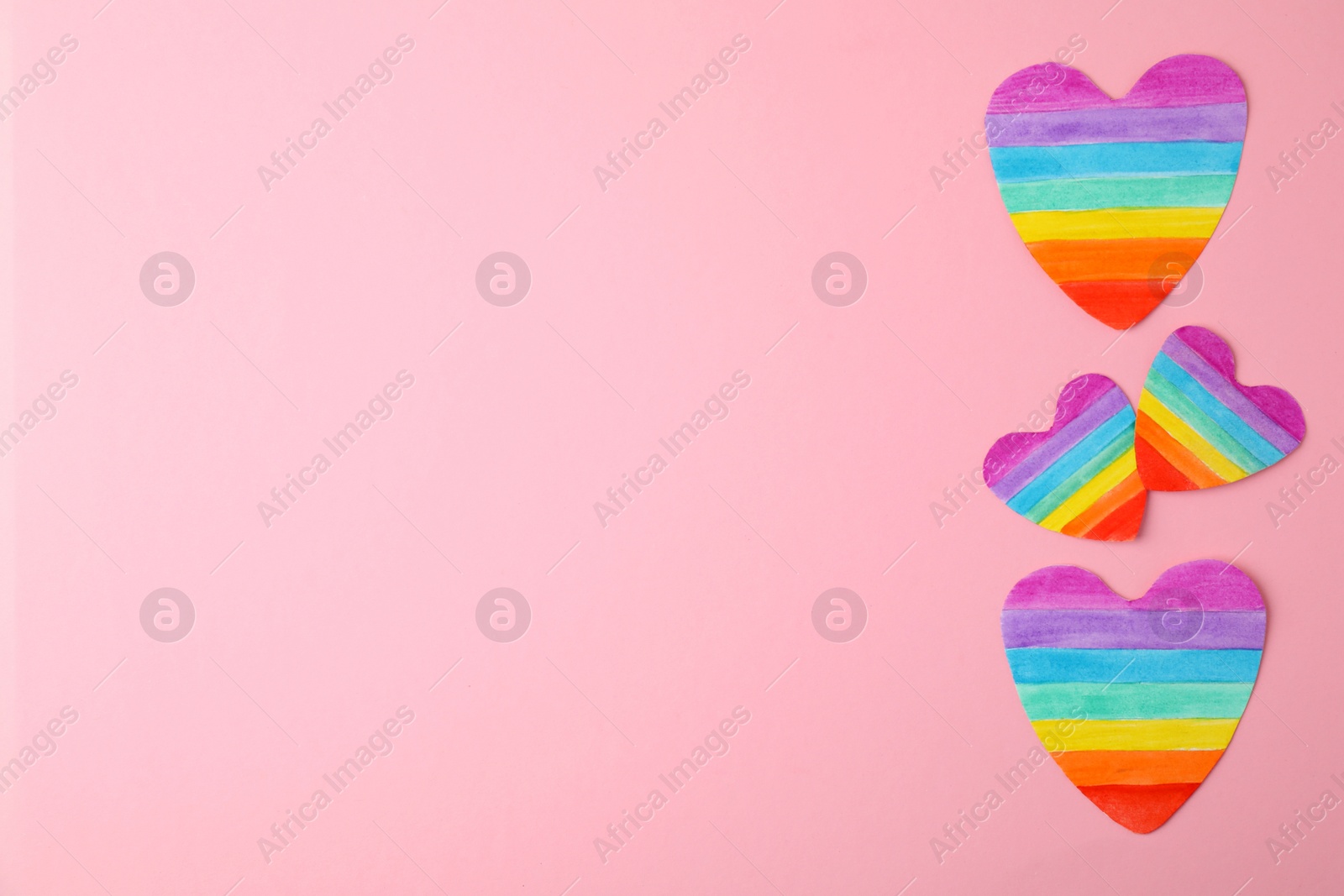 Photo of Top view of rainbow hearts on color background, space for text. Gay symbol