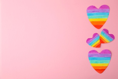 Photo of Top view of rainbow hearts on color background, space for text. Gay symbol