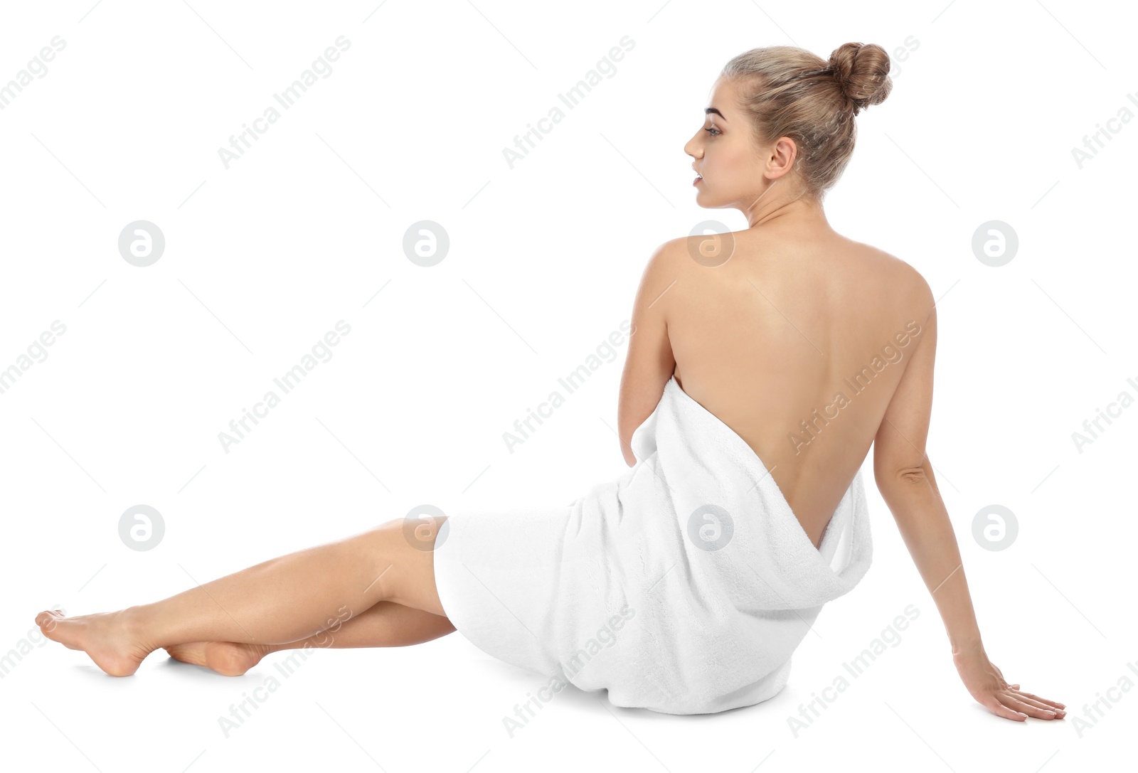 Photo of Young woman with soft towel sitting on white background