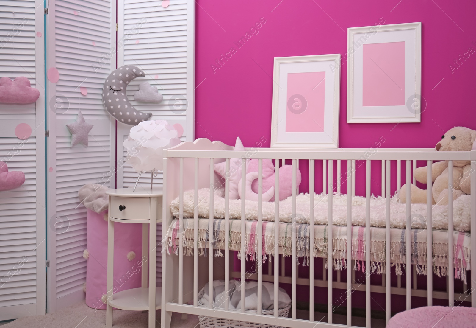 Photo of Baby room interior with crib near color wall