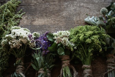 Photo of Bunches of different beautiful dried flowers on wooden table, flat lay