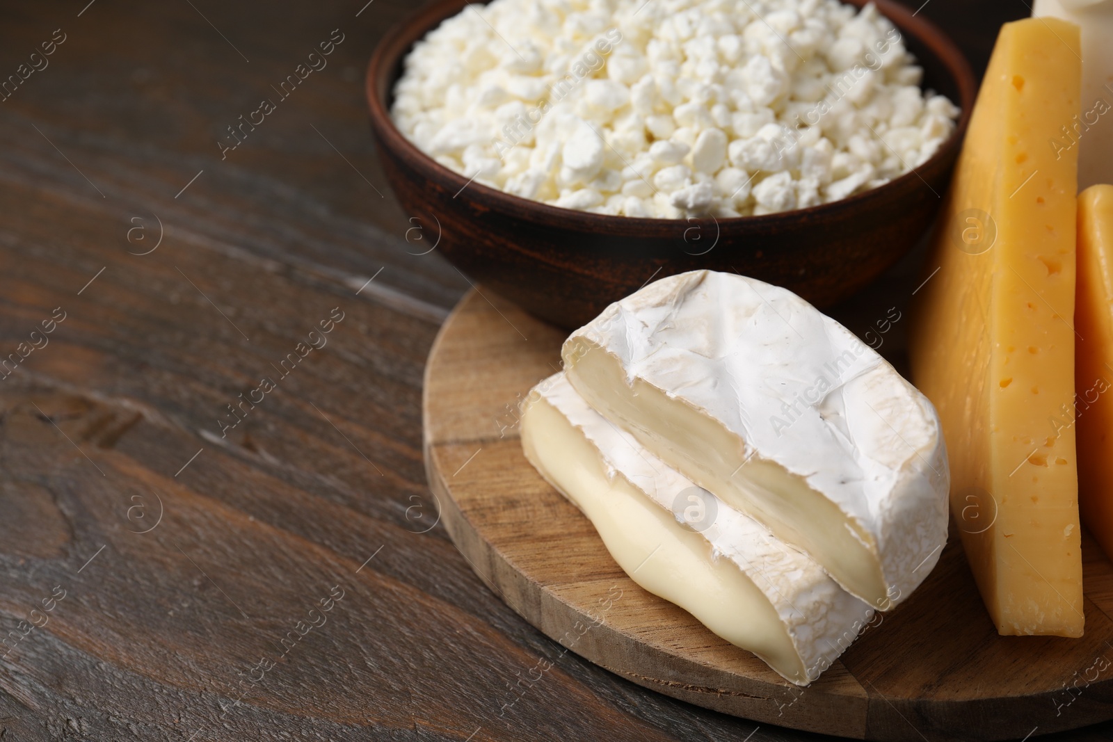 Photo of Dairy products. Different kinds of cheese on wooden table, closeup. Space for text