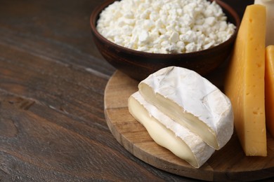 Photo of Dairy products. Different kinds of cheese on wooden table, closeup. Space for text