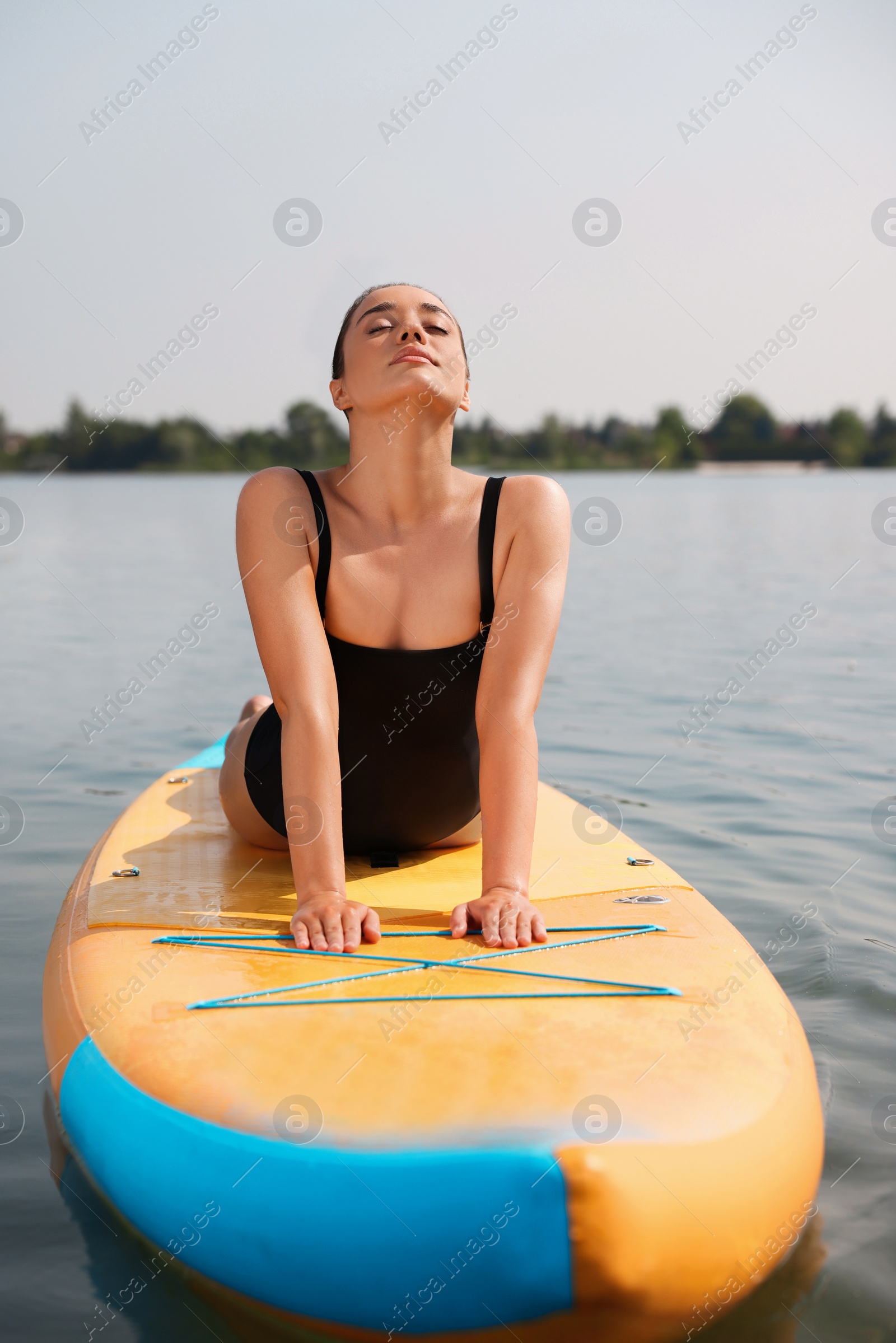 Photo of Woman practicing yoga on SUP board on river