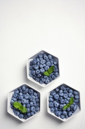 Photo of Flat lay composition with fresh blueberries, green leaves and space for text on table
