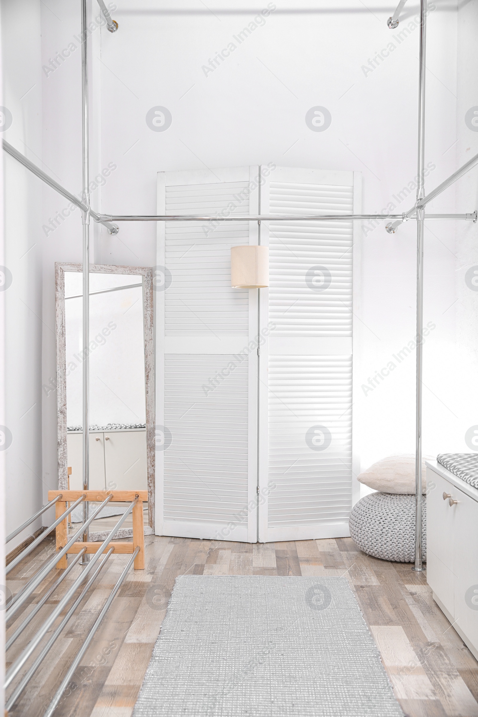 Photo of Empty modern dressing room with racks and hangers