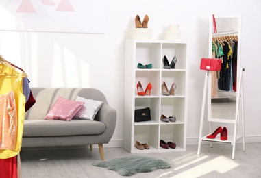 Photo of Shelving unit with shoes and purses in stylish dressing room interior