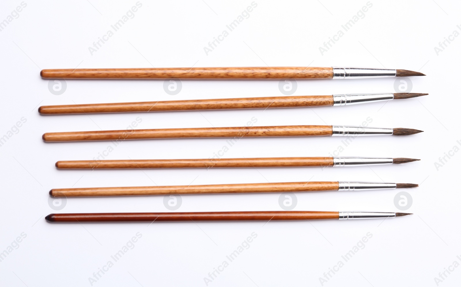 Photo of Different paint brushes on white background, top view