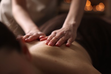 Photo of Spa therapy. Beautiful young woman lying on table during massage in salon, closeup