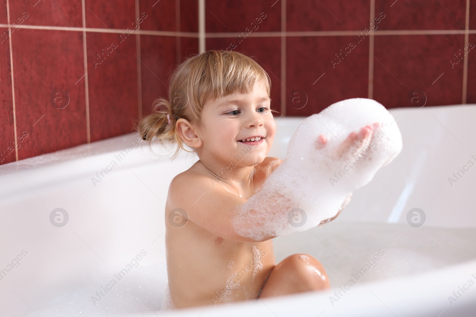 Photo of Happy girl having fun in bathtub at home