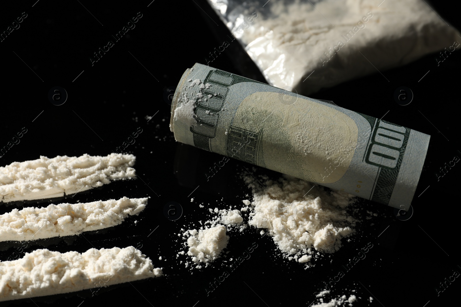 Photo of Drug addiction. Cocaine and rolled dollar banknote on black table, closeup