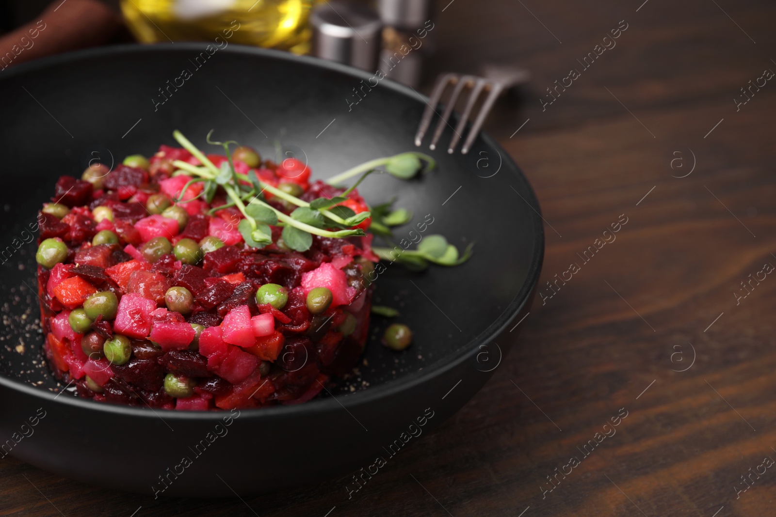 Photo of Delicious vinaigrette salad on wooden table, closeup. Space for text