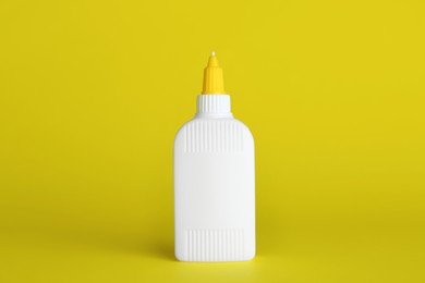 Photo of Blank bottle of glue on yellow background
