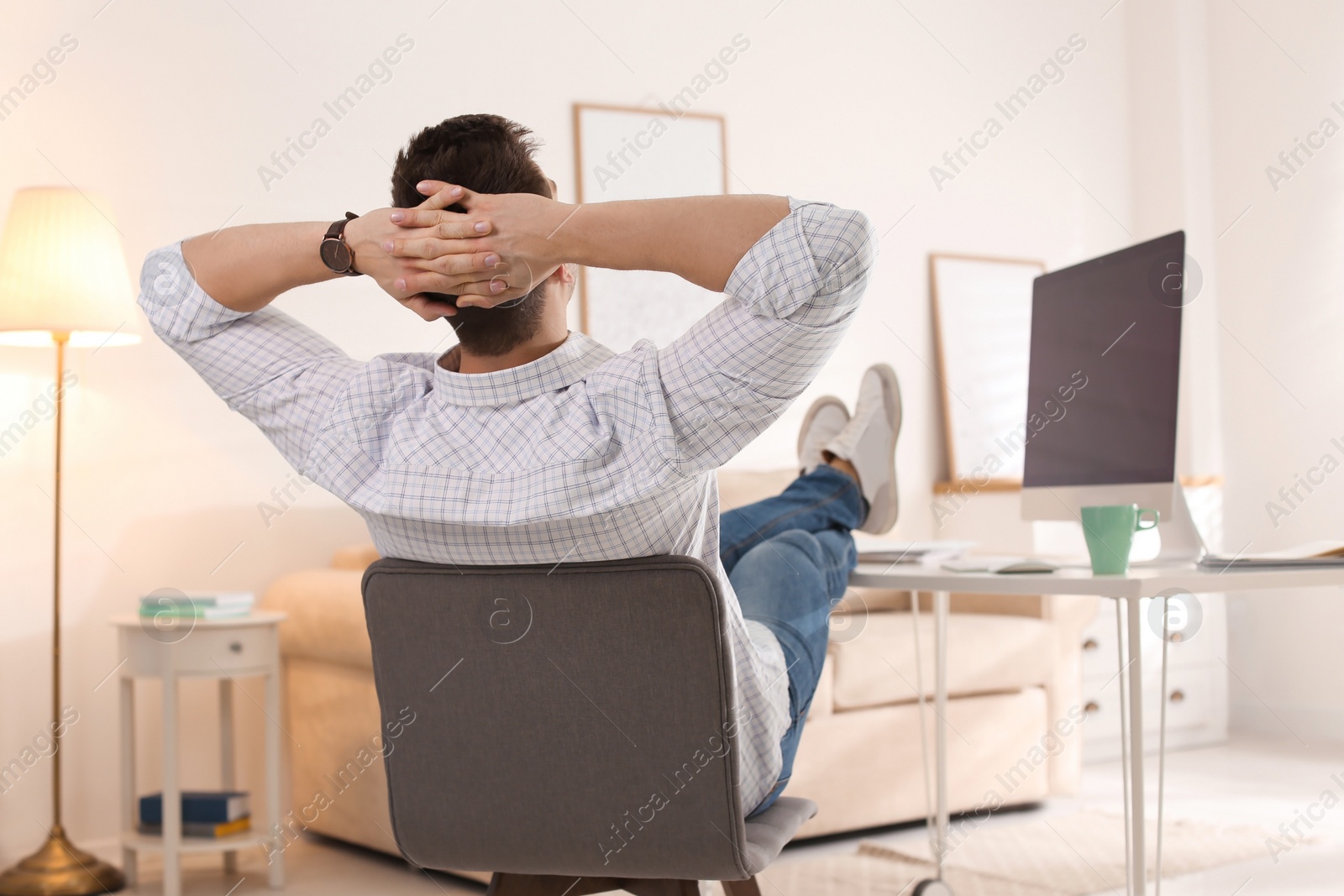 Photo of Young man relaxing at table in office during break