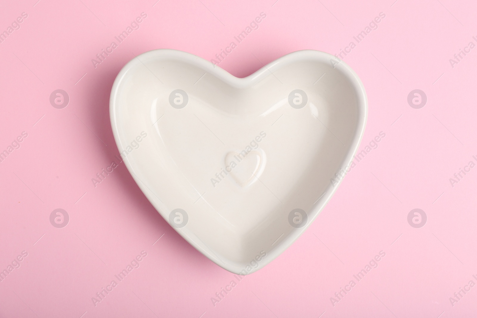 Photo of Empty heart shaped bowl on color background, top view