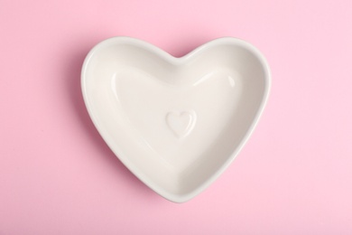 Photo of Empty heart shaped bowl on color background, top view