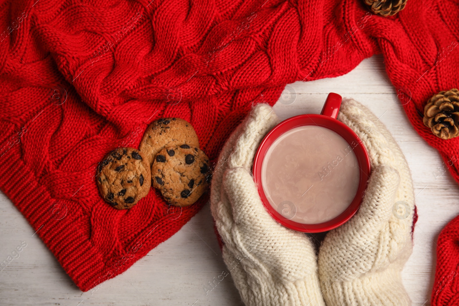 Photo of Woman with cup of hot cocoa at table, top view. Winter drink