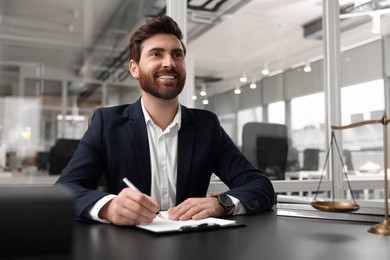 Portrait of smiling lawyer at table in office