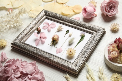 Photo of Composition with beautiful dry flowers and vintage frame on white wooden background