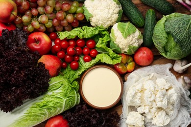 Different fresh ripe vegetables, sour cream, cottage cheese and fruits on table, flat lay. Farmer produce