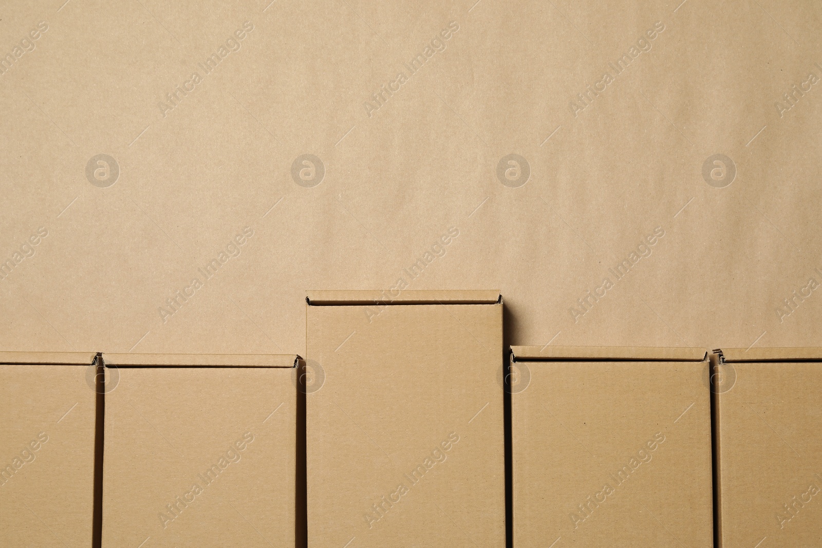 Photo of Many closed cardboard boxes on light brown background, flat lay. Space for text