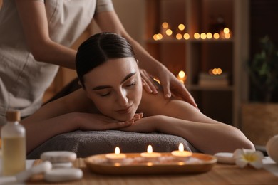 Photo of Spa therapy. Beautiful young woman lying on table during massage in salon