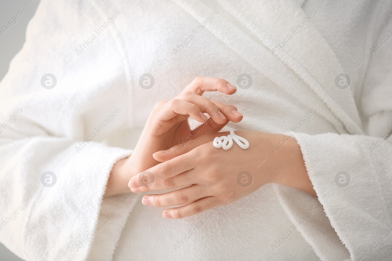 Photo of Young woman applying hand cream, closeup