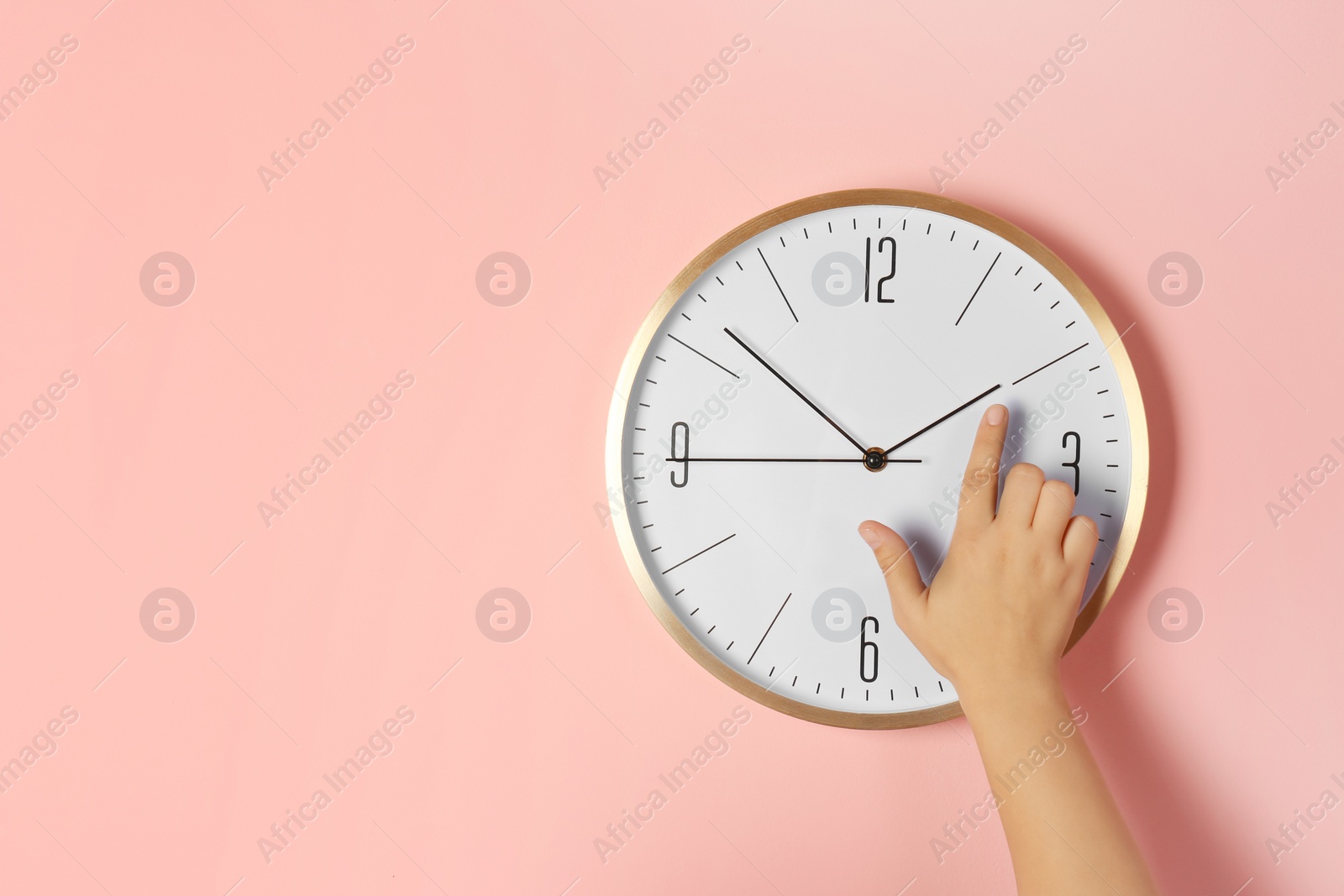 Photo of Woman touching clock on color wall, space for text. Time management