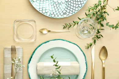 Photo of Elegant table setting with flowers and leaves, flat lay