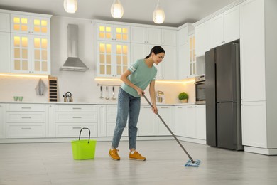 Woman cleaning floor with mop at home