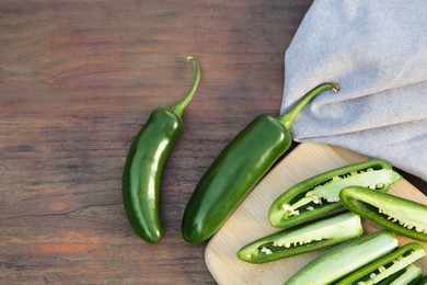 Fresh green jalapeno peppers on wooden table, flat lay. Space for text